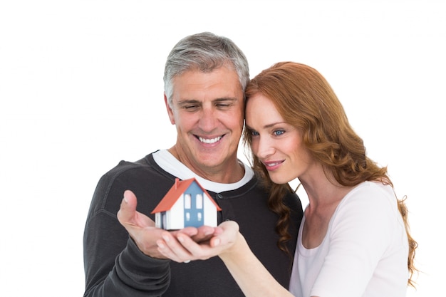 Casual couple holding small house