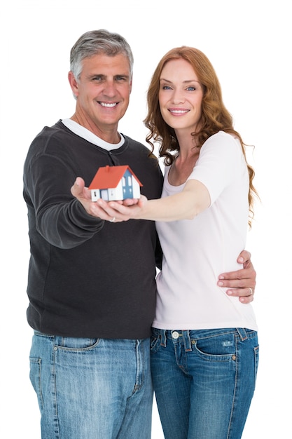 Casual couple holding small house