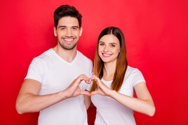 Casual couple posing against the red wall