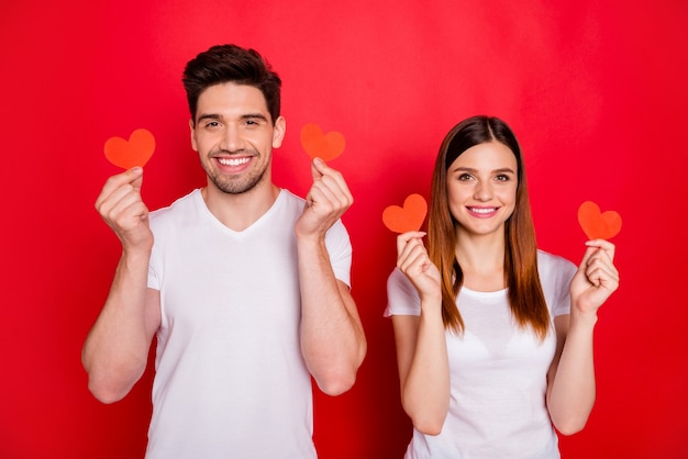 Casual couple posing against the red wall