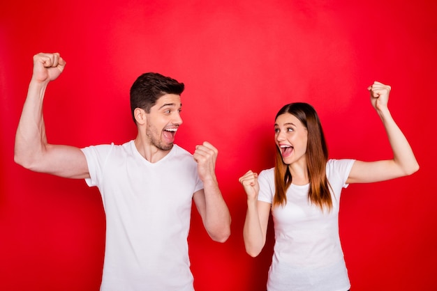 Casual couple posing against the red wall