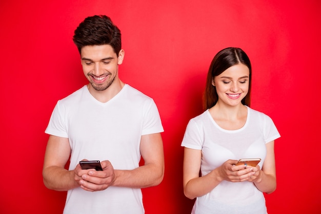 Casual couple posing against the red wall