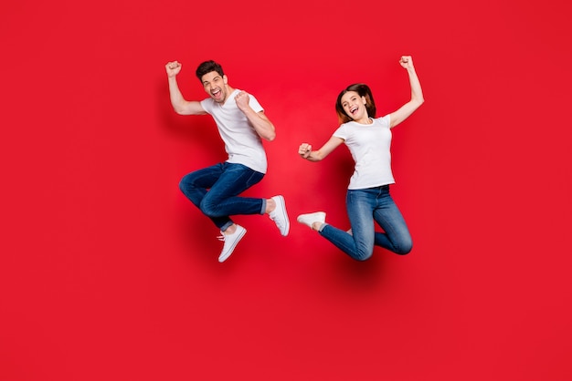 Casual couple posing against the red wall