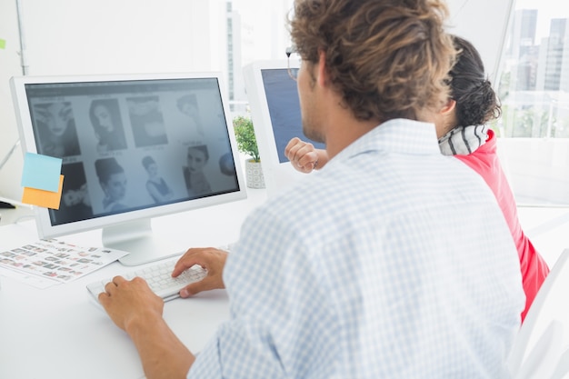 Casual couple using computer in office