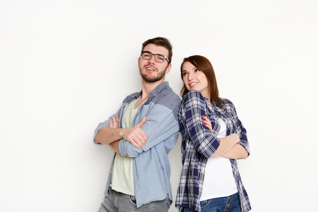 Casual couple on white isolated background standing back to back, posing to camera