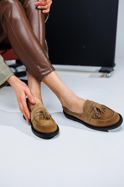 Casual damesmode Klassieke schoenen voor dames Slanke vrouwelijke benen in broeken en bruine stijlvolle casual loafers Comfortabele zomerschoenen voor dames