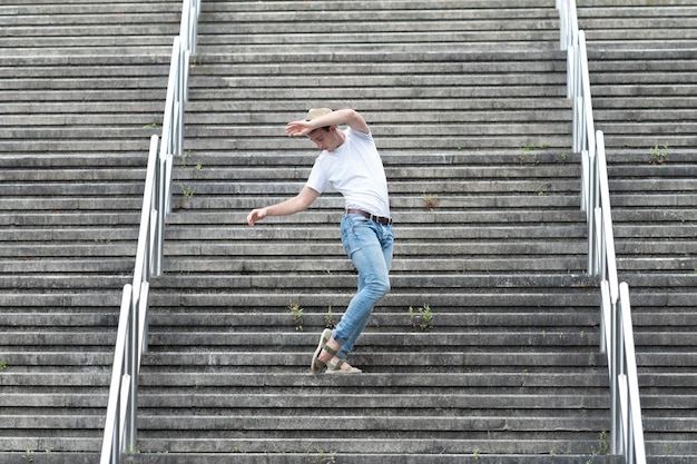 Foto uomo vestito casual che balla e festeggia su una scala