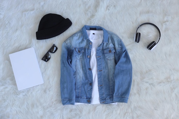 Casual fashion flat lay blue denim jacket and white shirt with headphone, beanie, sunglasses