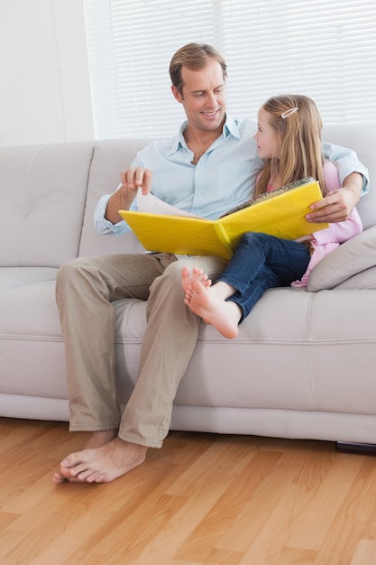 Casual father and daughter looking at photo album