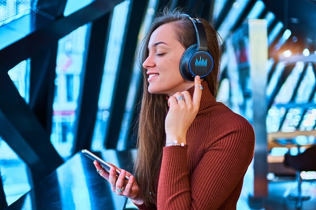 Casual gelukkig jonge Kaukasische stijlvolle brunette muziekliefhebber vrouw met draadloze koptelefoon