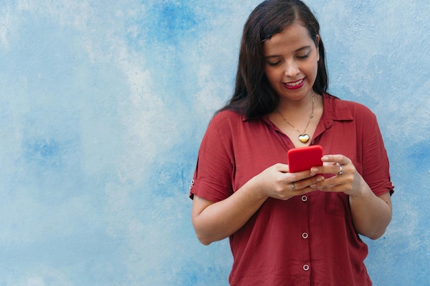 Casual girl checking her cell phone while standing outdoors on the street