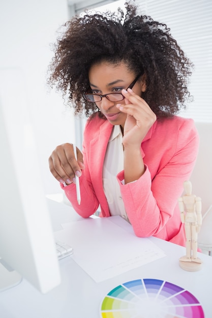 Casual graphic designer working at her desk  