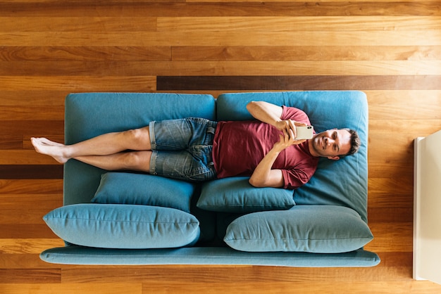 Casual guy on armchair with smartphone