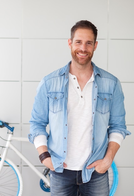 Casual guy next to his bike looking at camera