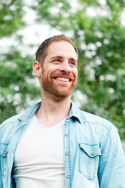 Photo casual guy with a denim shirt in a park