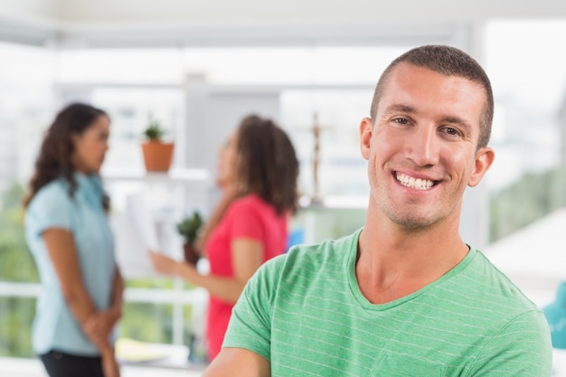  Casual male artist with colleagues in background at office