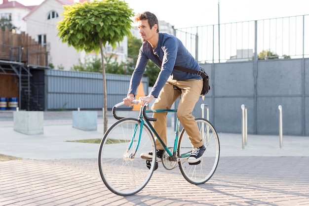 Photo casual male riding bicycle outdoors