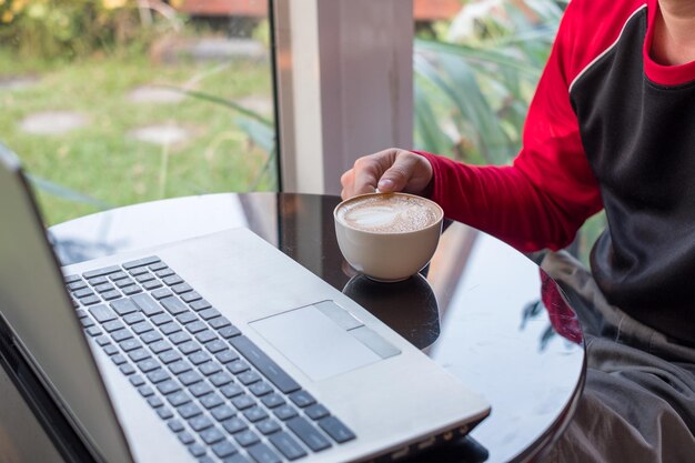 Casual man aan het werk met laptop en koffie drinken in de coffeeshop