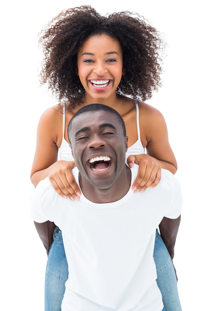 Photo casual man giving his smiling girlfriend a piggy back