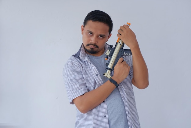 Casual man holding machine gun toy