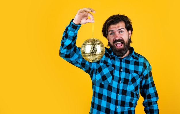 Casual man met glanzende discobal grappige en vrolijke man die plezier heeft op feest voor de lol bebaarde hipster klaar om de vakantie vakantie decor concept kopie ruimte te vieren