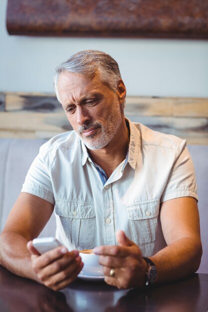 Casual man using mobile phone in coffee shop