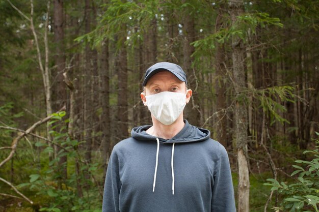 Фото Неформальный мужчина, носящий медицинскую защитную маску на открытом воздухе