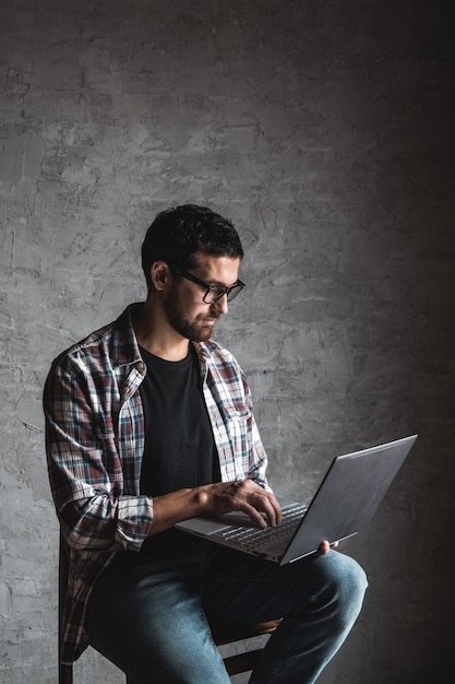 Casual man with laptop on gray