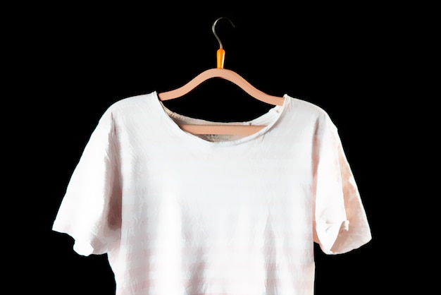 Photo casual men t-shirt on a hanger on the dark wall