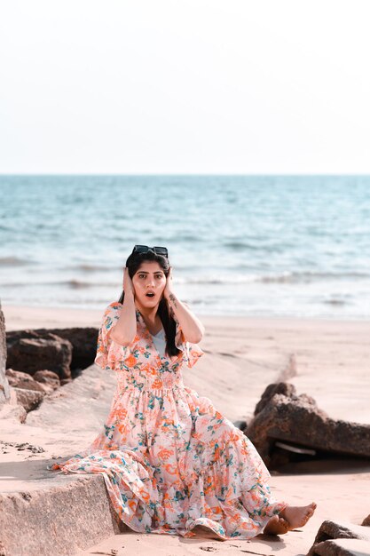 casual mooi meisje voorkant pose handen op oren op strand Indiase Pakistaanse model