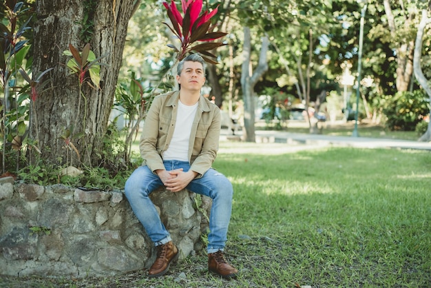 Casual portrait of young grayhaired man spending time in a garden