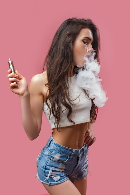 カジュアルなきれいな女性に立っているとvaping