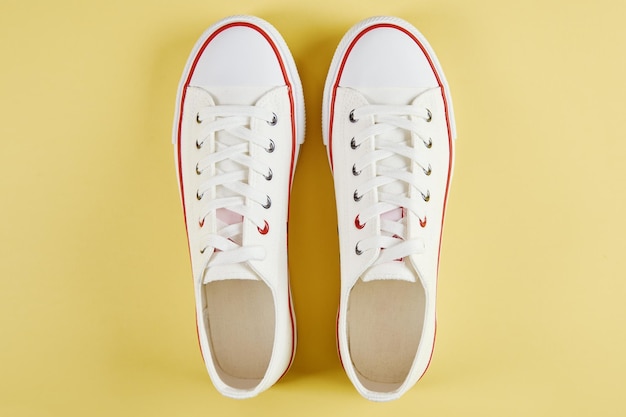 Photo casual sneakers on yellow background creative minimalism
