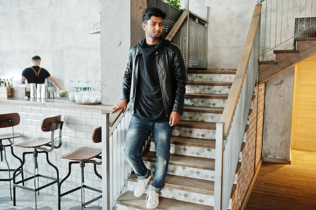 Casual and stylish young asian man wear on leather jacket standing on stairs at cafe