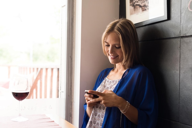 Casual vrouw met behulp van smartphone bij coffeeshop