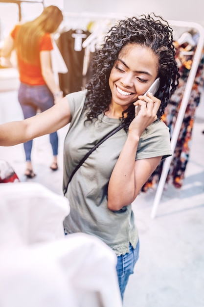 Casual vrouw met telefoon in de winkel