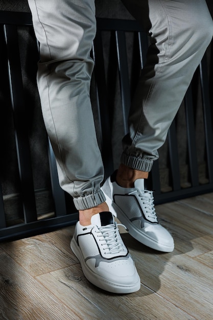 Foto sneakers bianche casual da uomo gambe maschili in pelle bianca scarpe estive comode sneakers bianche da uomo con lacci