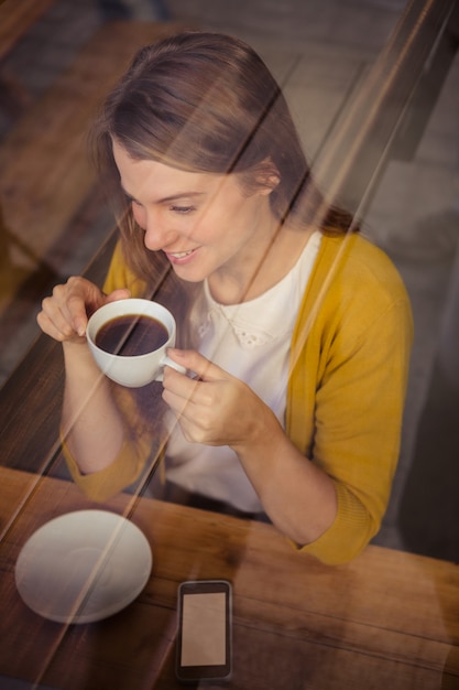 コーヒーを飲みながらカジュアルな女性