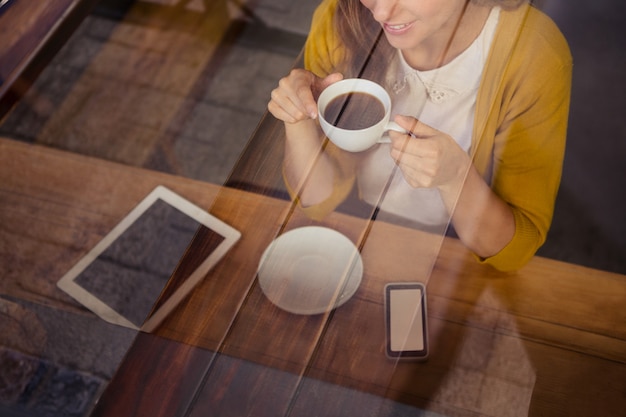 コーヒーを飲みながらカジュアルな女性