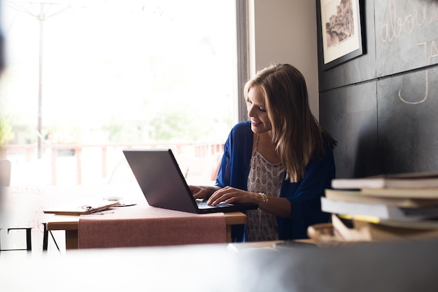 Casual woman using laptop at coffee shop