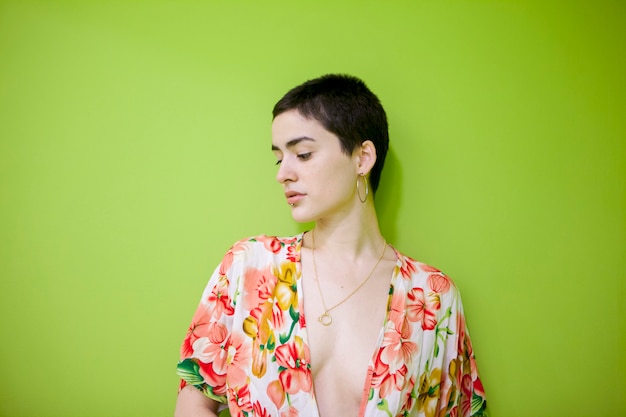 Casual woman with short hair isolated on a green wall
