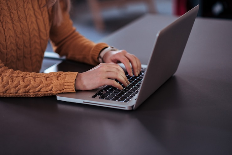 Photo casual woman working on laptop. close-up.