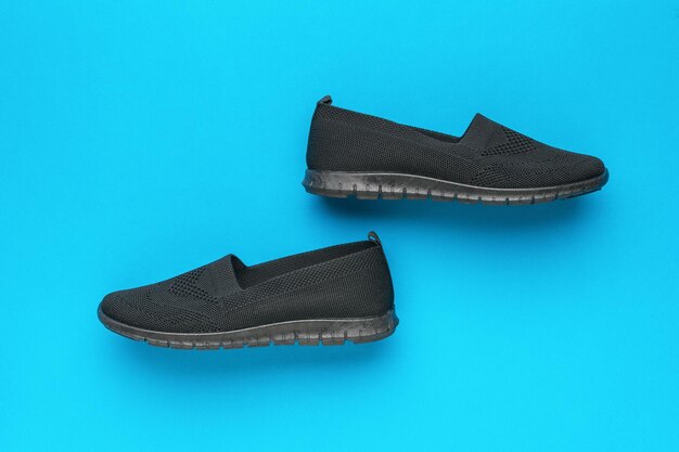 Casual womens shoes in black on a blue background