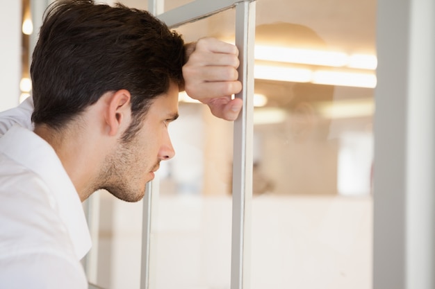 Photo casual worried businessman leaning against the window