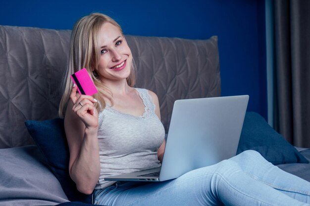 Casual young woman doing online shopping in bed