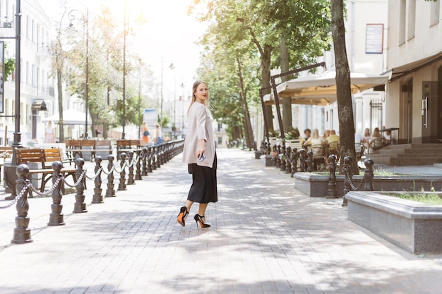 Casual young woman walking along a city street