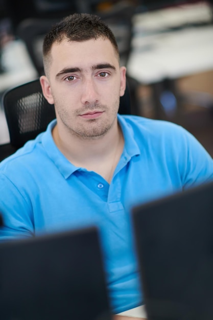 Foto casual zakenman aan het werk op een desktopcomputer in een modern open startbureau-interieur