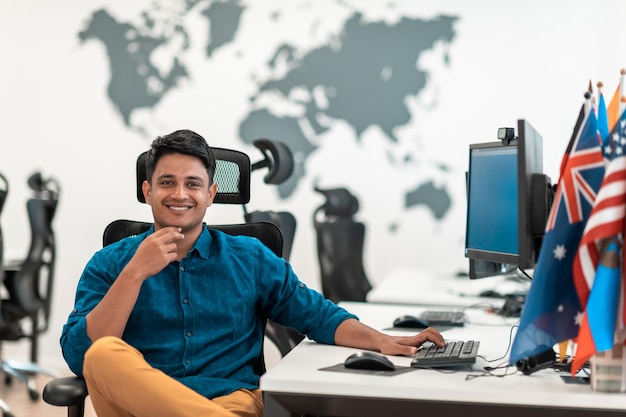 Casual zakenman die op een desktopcomputer werkt in een modern open startkantoor Selectieve aandacht. Foto van hoge kwaliteit