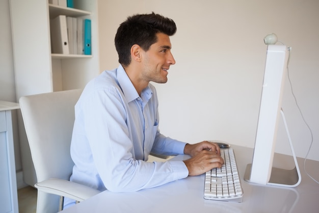 Casual zakenman typen op zijn bureau