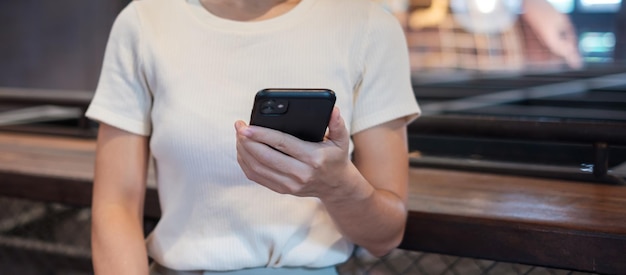 Casual zakenvrouw die smartphone vasthoudt en gebruikt voor sms-berichten jonge vrouw touchscreen mobiele telefoon typt in café of moderne kantoorlevensstijltechnologie Sociale media en netwerkconcept